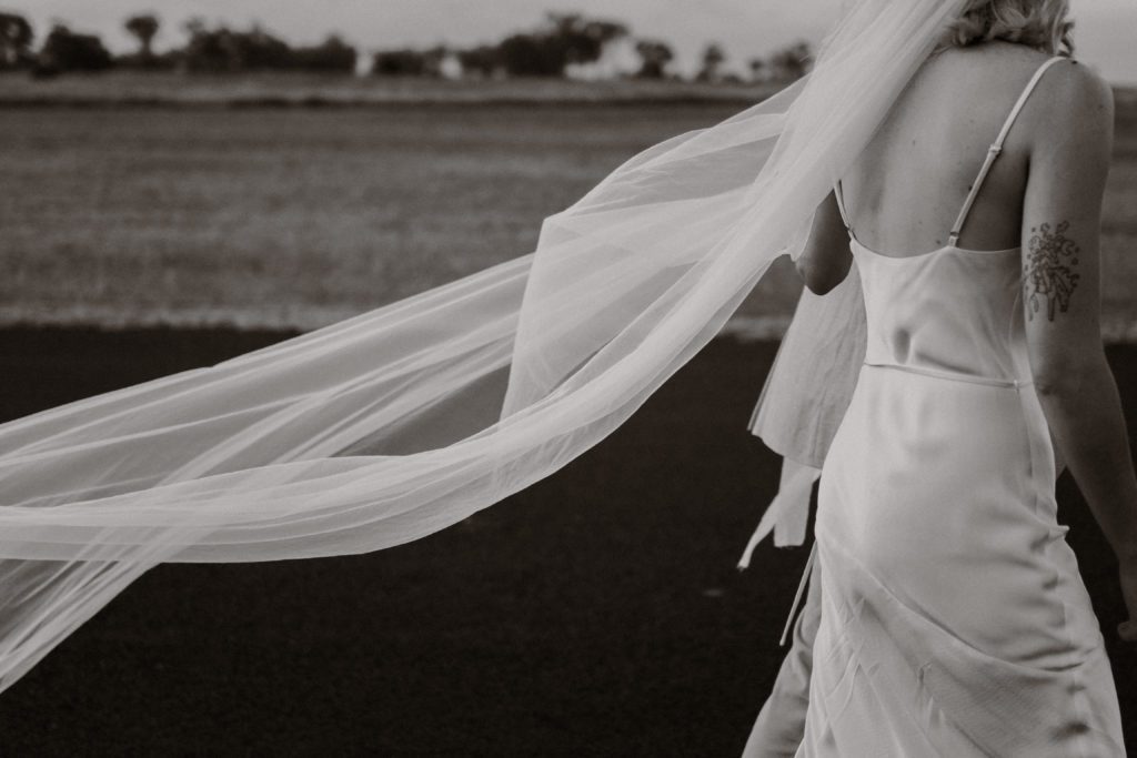 Bride + Groom walking along the airstrip